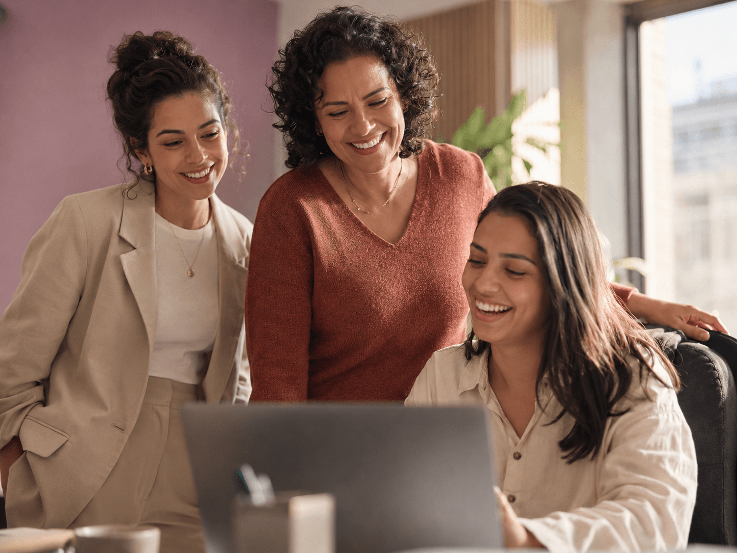 Equipe de qualidade reunida em frente ao notebook, calibrando a avaliação de um atendimento